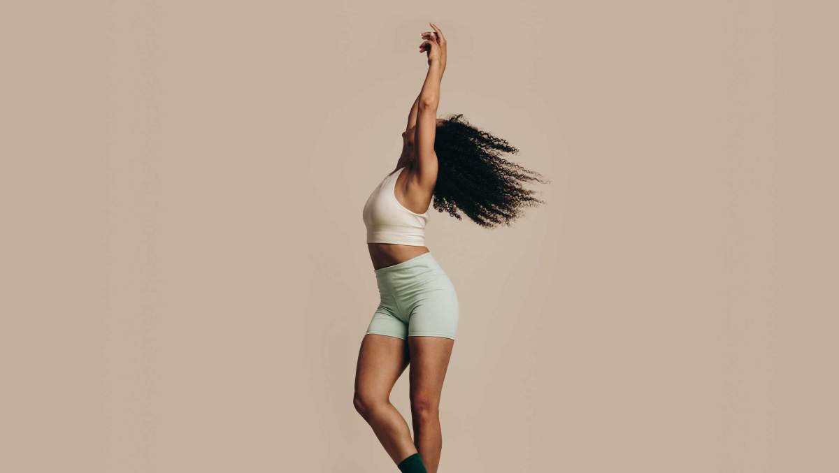 Fit junge Frau zeigt ihre Flexibilität und Balance mit einem Tanz