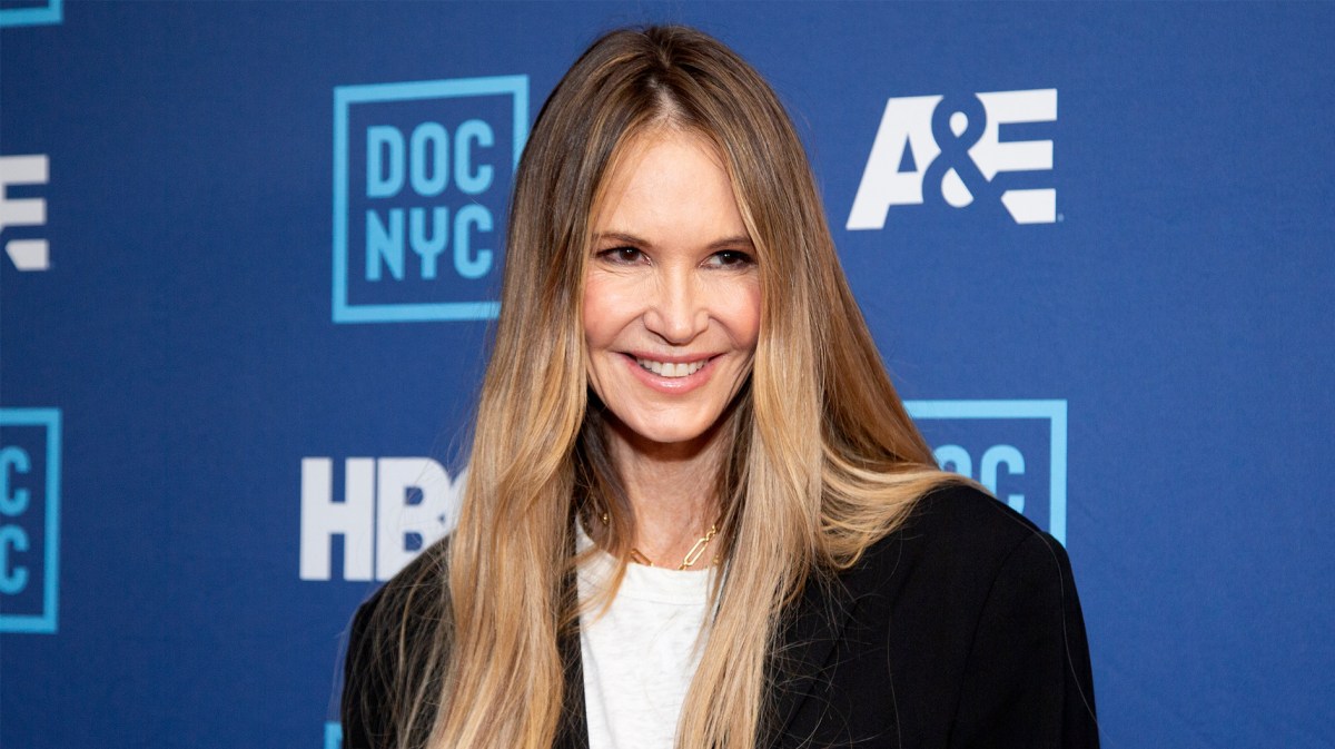 Elle McPherson mit langem, glatten Haar, die in die Kamera lächelt.
