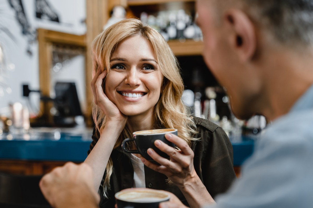 Eine Frau mit einer Kaffeetasse in der Hand, auf einem Date.