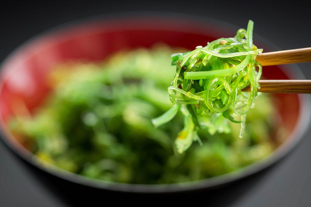 Algensalat aus roter Schüssel, mit Stäbchen essen