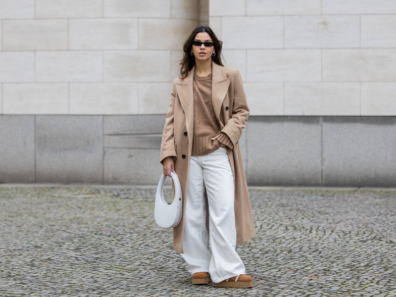 Influencerin trägt eine weiße Jeans zum Oversize-Mantel.