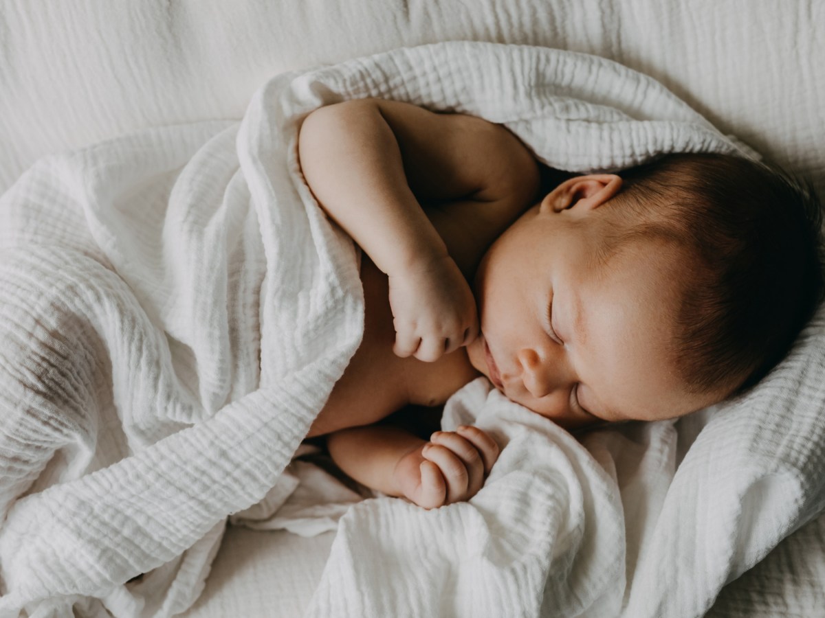 Baby eingewickelt in Decke am Schlafen