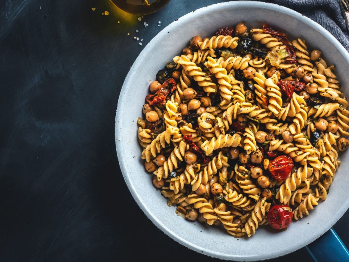 Nudelsalat mit Tomaten, Oliven und Kirchererbsen in einer Pfanne