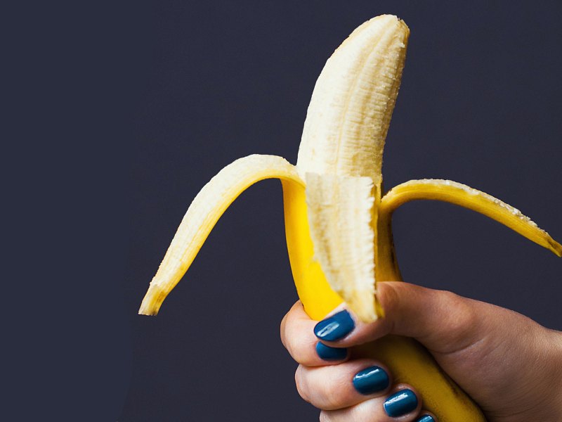Frauenhand hält eine Banane