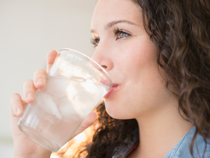 Junge Frau trinkt ein Glas Wasser