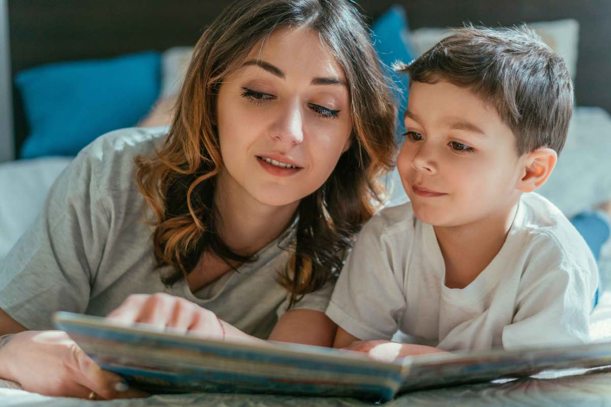 Mutter liest ihrem Sohn aus einem Buch vor.