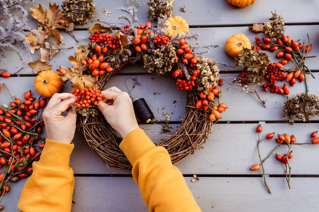 Mädchen bastelt Herbstkranz.