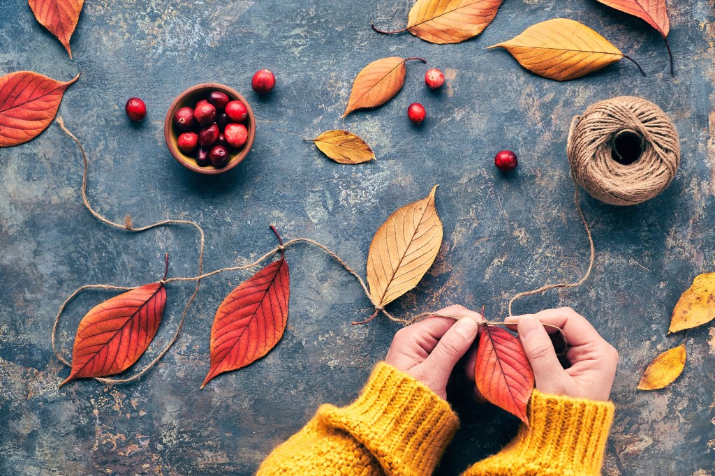 Person basteln eine Laubgirlande für den Herbst.