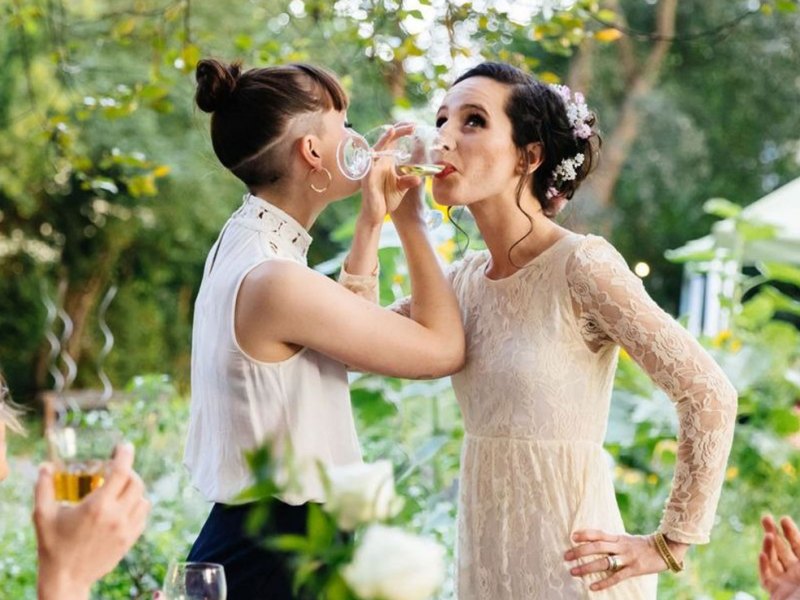 Zwei Frauen trinken auf ihrer Hochzeit Brüderschaft