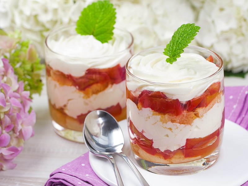 Zwei Dessertgläser mit Rhabarber Tiramisu daneben Hortensien in Lila als Deko