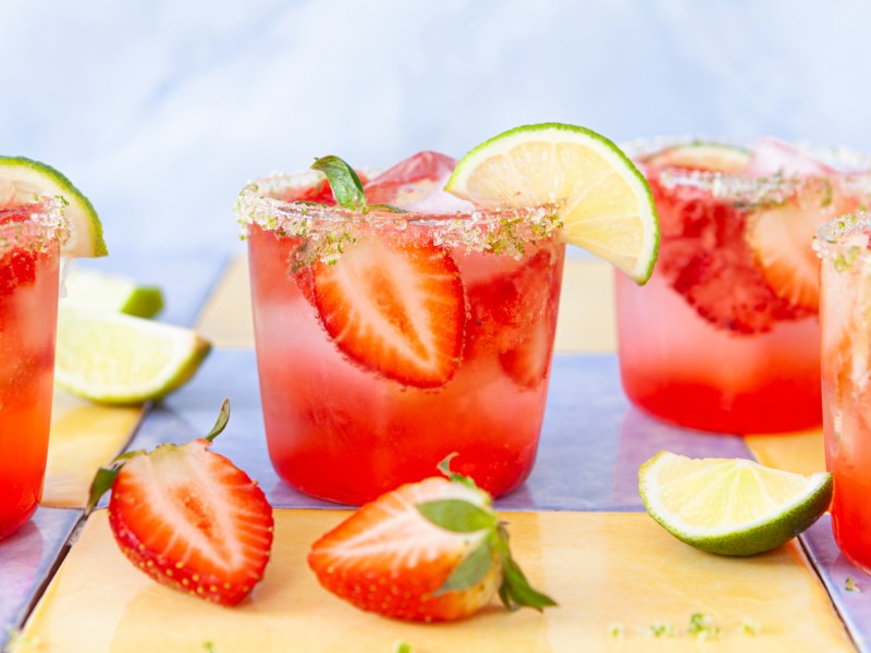 Mehrere Cocktailgläser mit Erdbeer Mojitos.