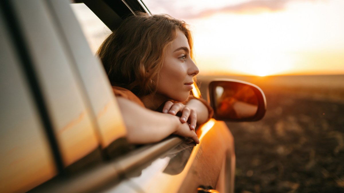 Frau schaut aus Autofenster.