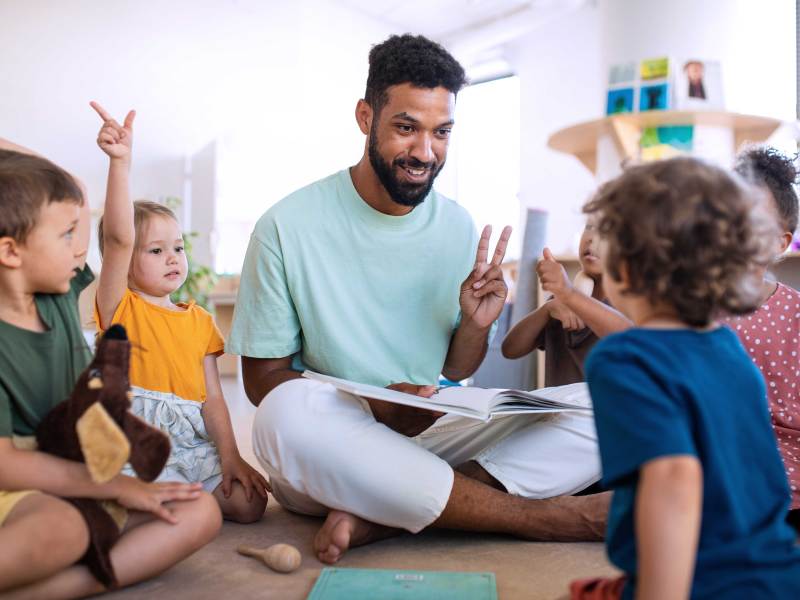 Kindergärtner übt zahlen mit ein paar Kindern.