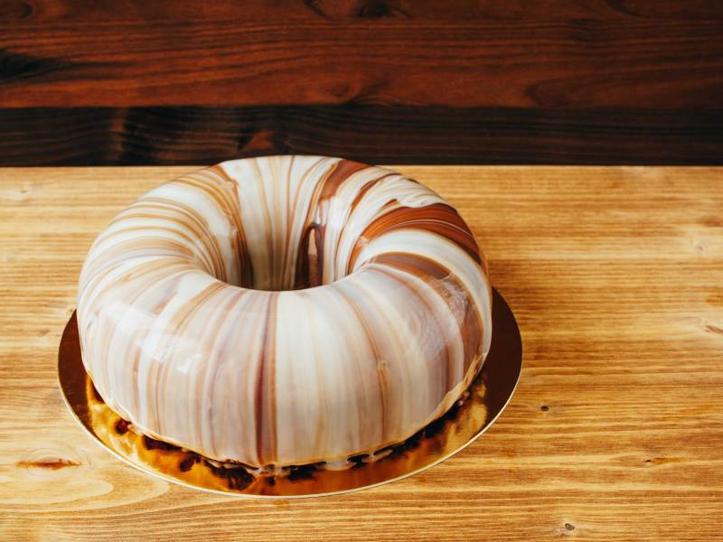 Nahaufnahme eines runden Kuchens, überzogen mit heller und dunkler Schokoglasur.