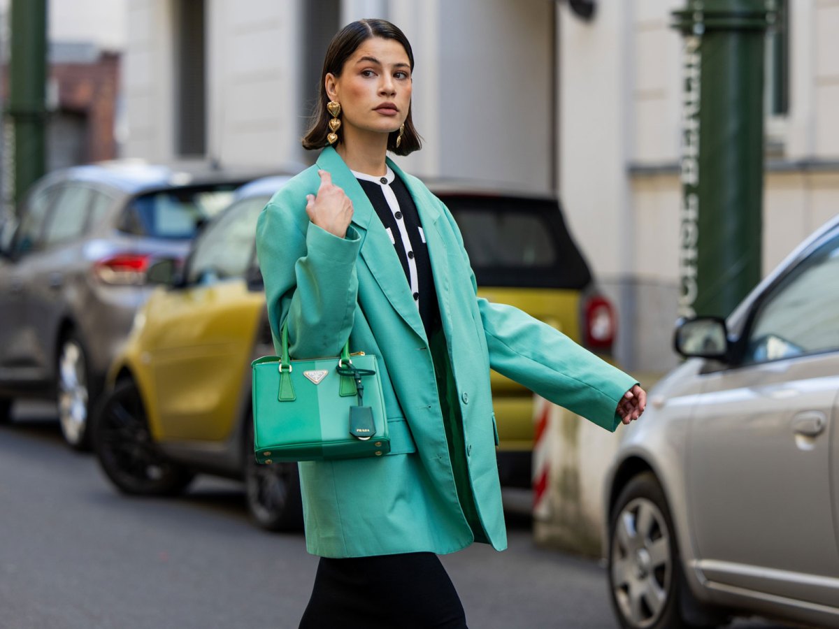Streetstyle: Frau mit kurzem braunen Haar trägt schwarzes Kleid und knallig grüne Jacke