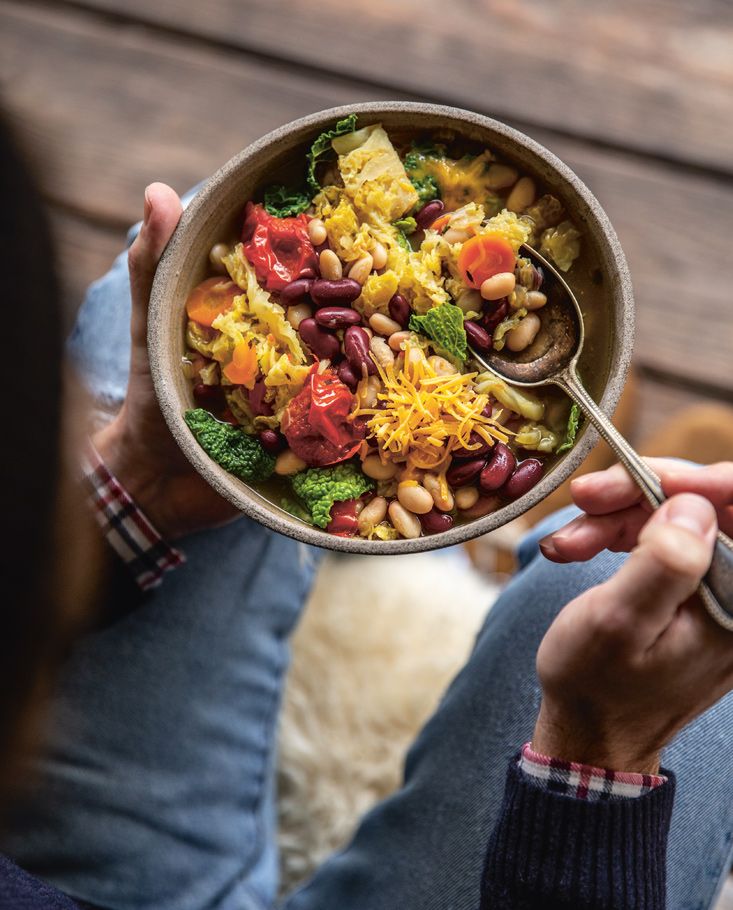 Person isst Bowl mit Salat und roten Bohnen.