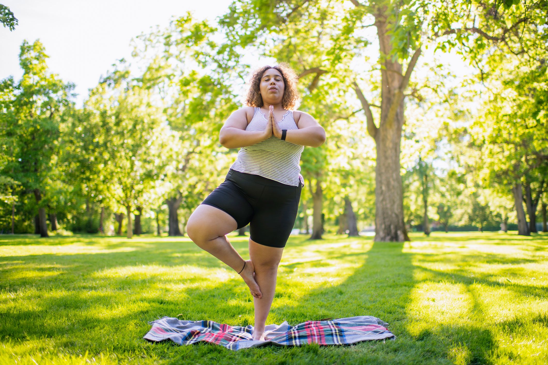 Frau macht im Park Yogaübung für Anfänger