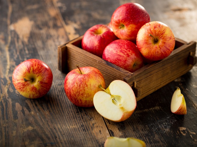 Äpfel in Holzkiste auf Holztisch