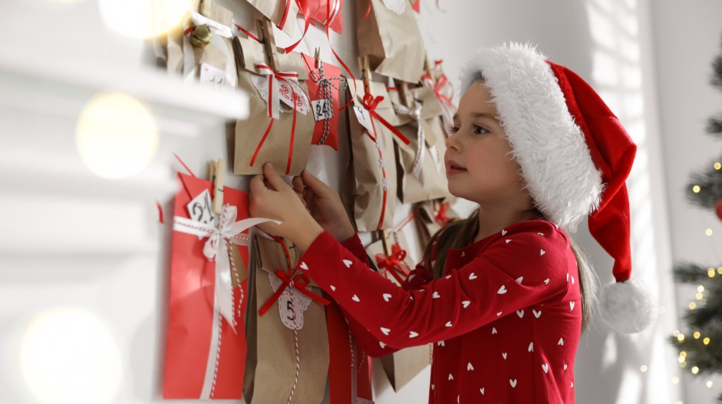 Mädchen öffnet Adventskalender.