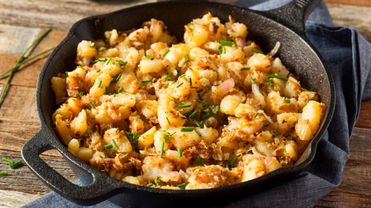 Bratkartoffeln mit Petersilie und schwarzer Pfanne.