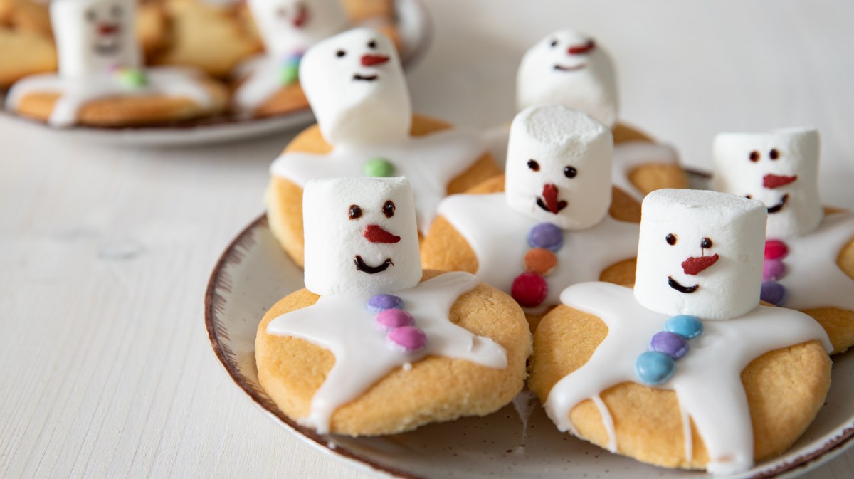 Schneemann Plätzchen mit Marshmallows auf Teller.