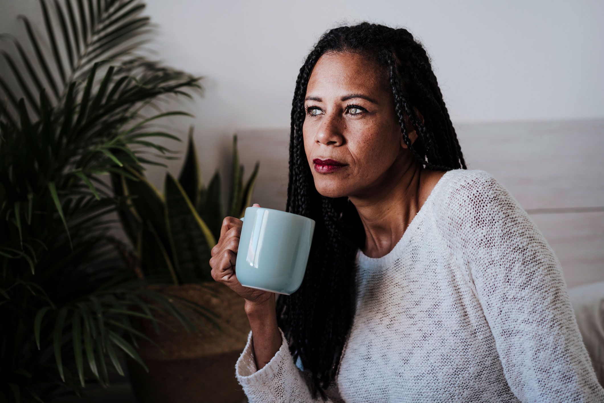 Frau circa 50 Jahre alt, grübelt über einer Tasse Tee