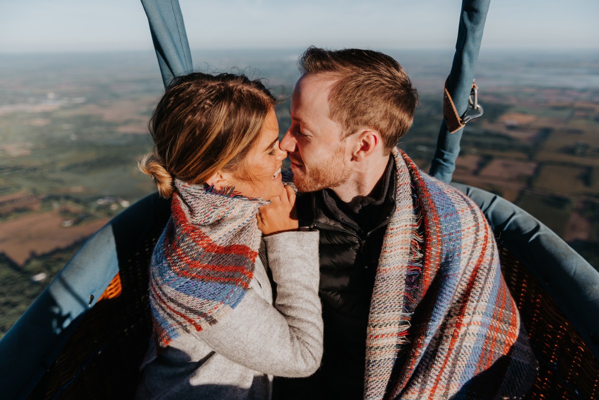 Frau und Mann küssen sich in Heißluftballon