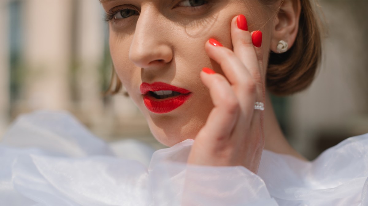 Frau mit roten Lippen und roten Nägeln.