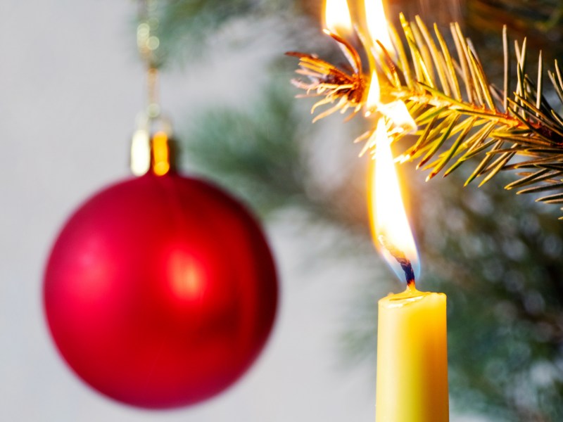 Kerze auf Weihnachtsbaum brennt Ast ab.