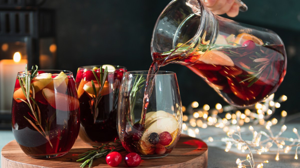Person gießt Sangria in Glas ein.