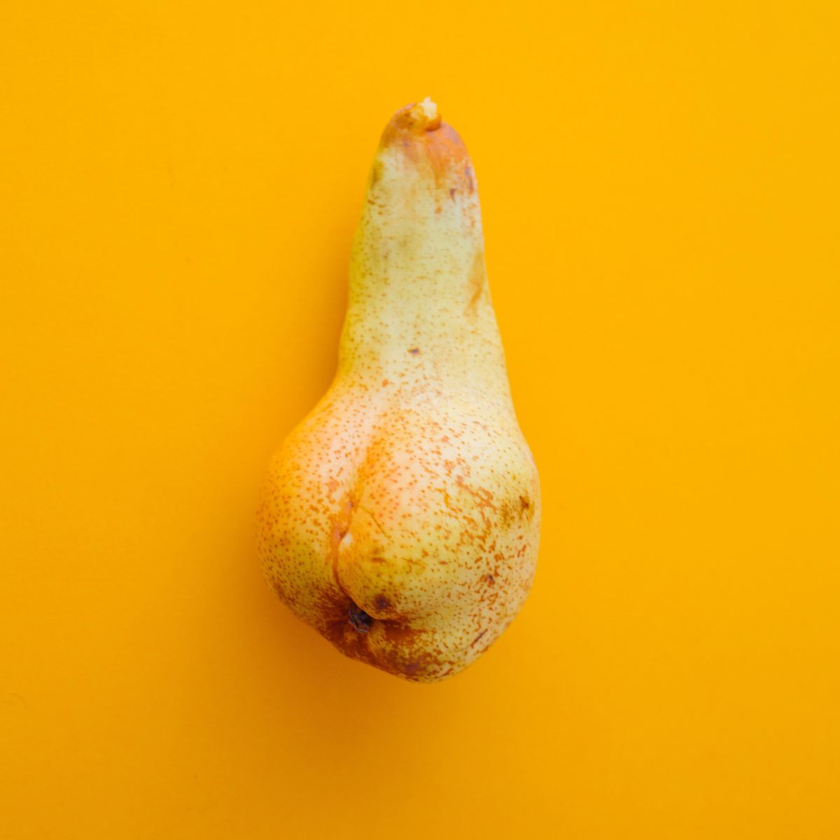 Eine Birne auf orangenem Hintergrund.