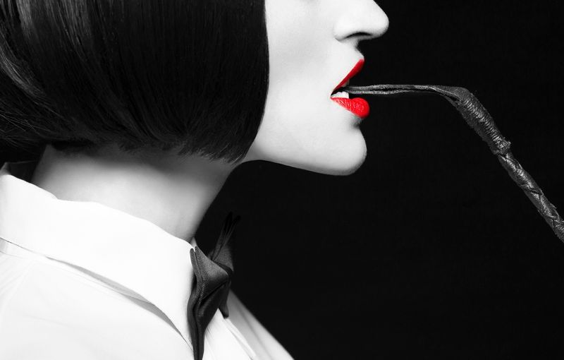 Frau mit schwarzen Haaren und rotem Lippenstift.