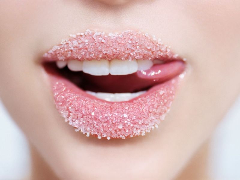 Weiblicher Mund mit Zucker auf den Lippen