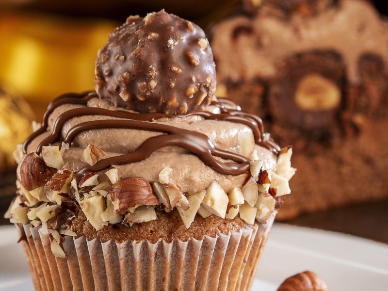 Ferrero Rocher Cupcake mit Haselnussstücken und Rocher auf der Spitze