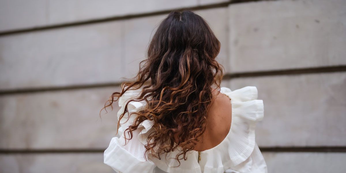 Frau mit langen lockigen Haaren.