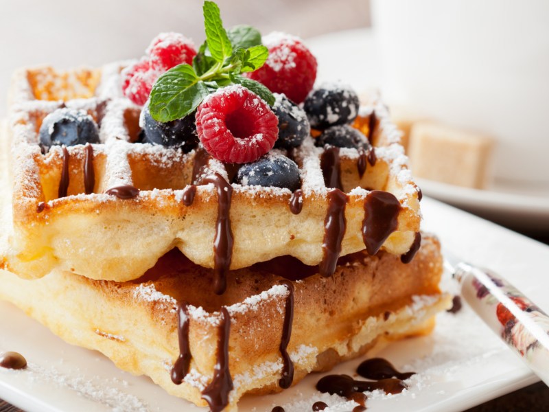 Belgische Waffeln auf weißem Teller, mit Puderzucker.