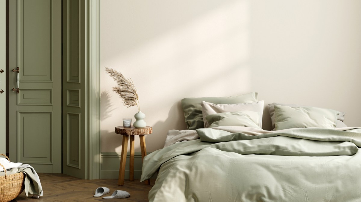 Modern eingerichtetes Schlafzimmer mit grünem Bettbezug.
