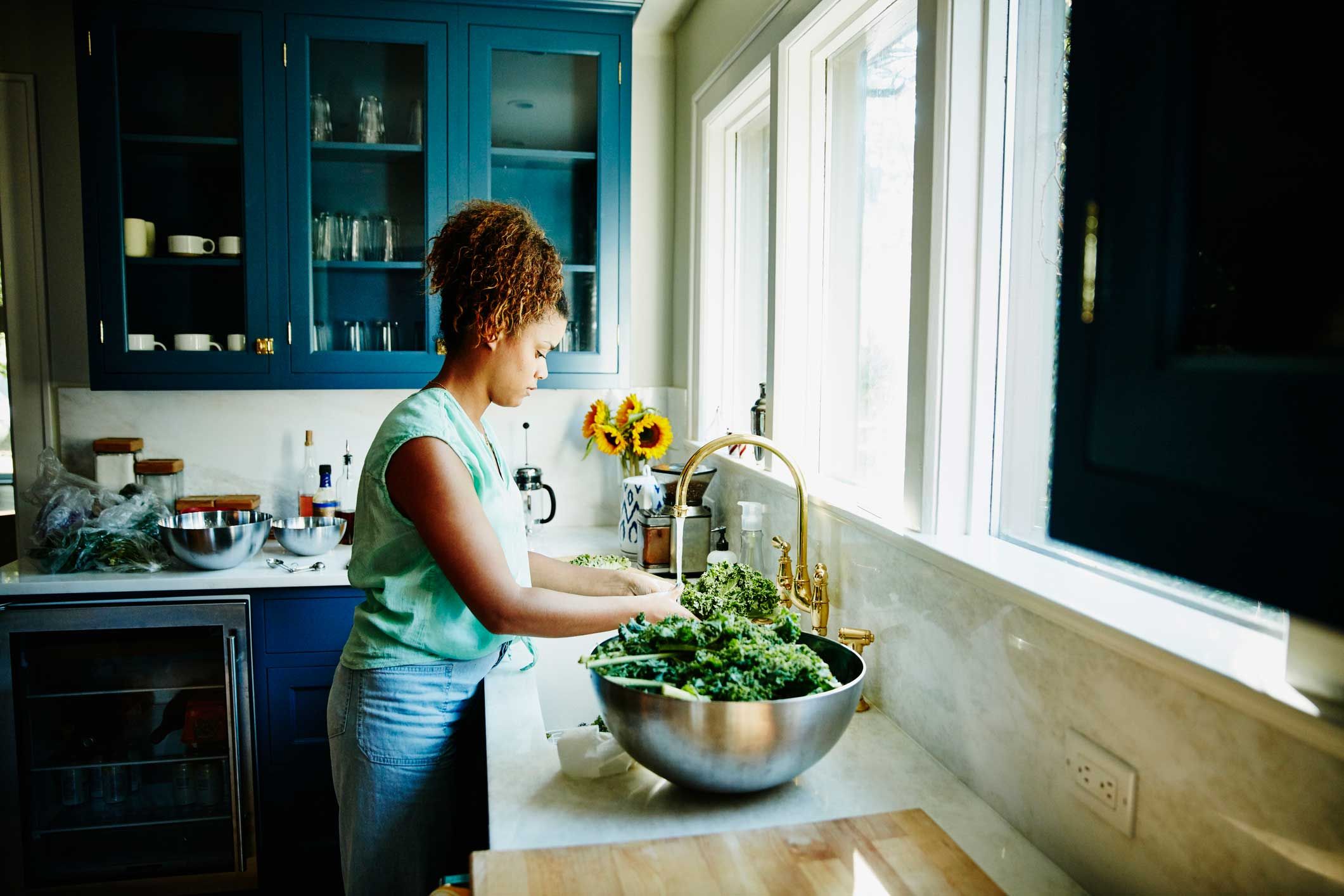 Frau bereitet in der Küche Grünkohl zu