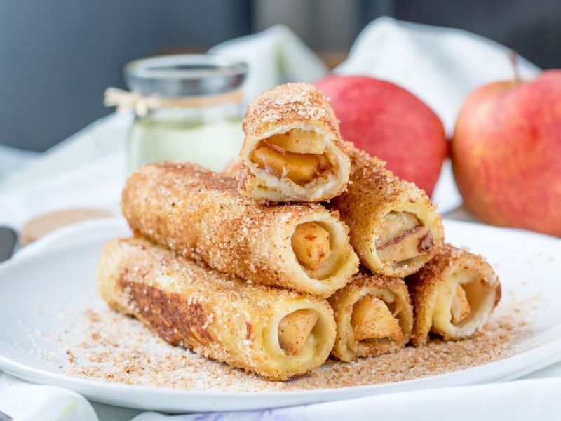 Apfel-Toast-Röllchen auf einem weißen Teller.