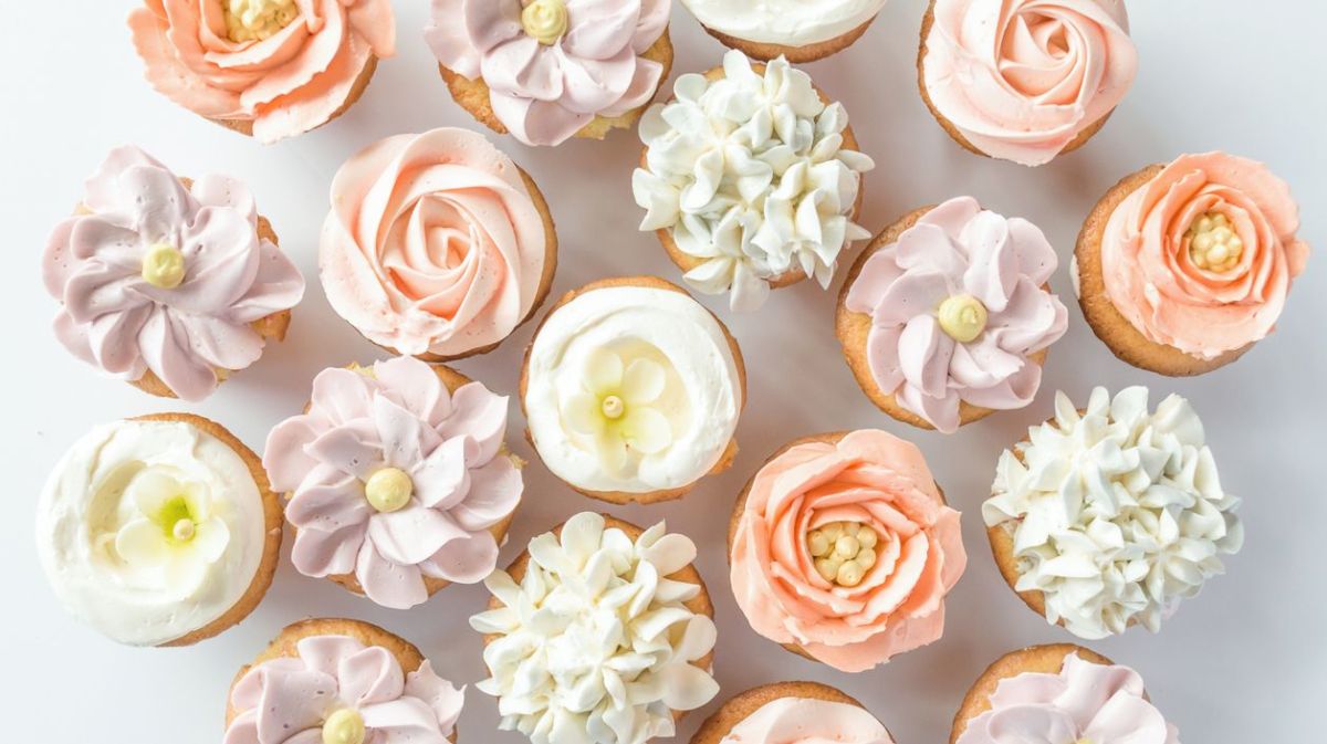 Mehrere Cupcake mit Blumen aus Buttercreme.