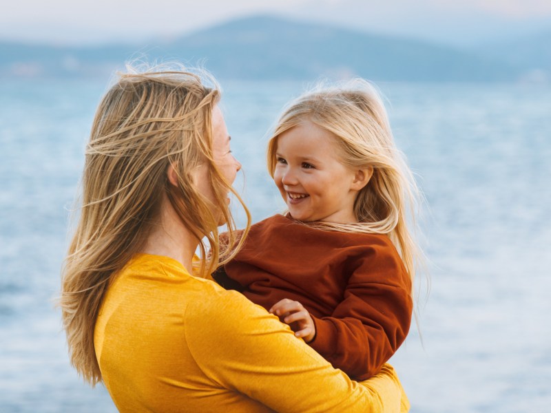 Mutter und Kind Tochter im Freien im Hintergrund eine Seelandschaft