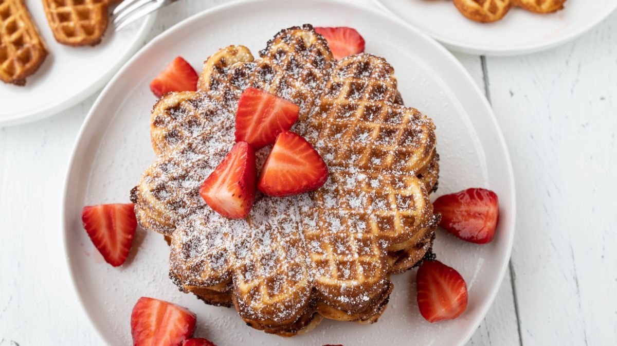 Waffeln mit Erdbeeren auf einem weißen Teller.