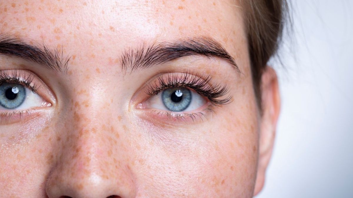 Nahaufnahme von Frau mit blauen Augen und Sommersprossen