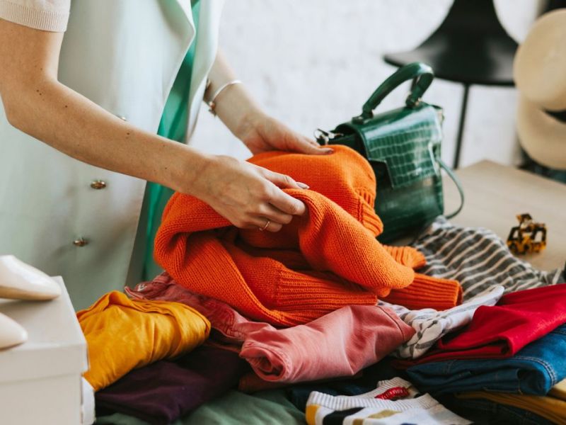 Frau schaut sich Kleidung auf Flohmarkt an