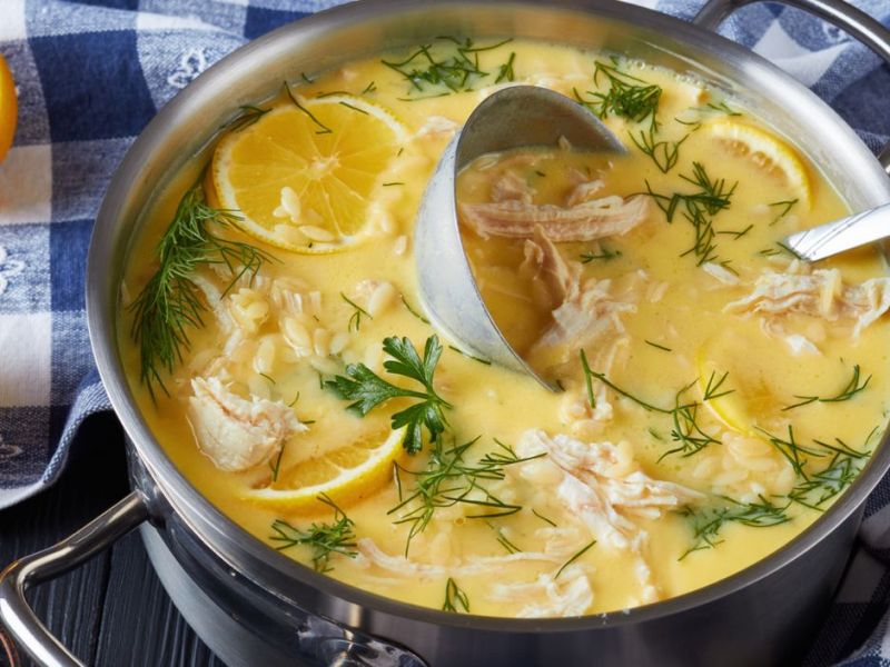 Großer Suppentopf mit Hühnersuppe, Zitronen und Reis.