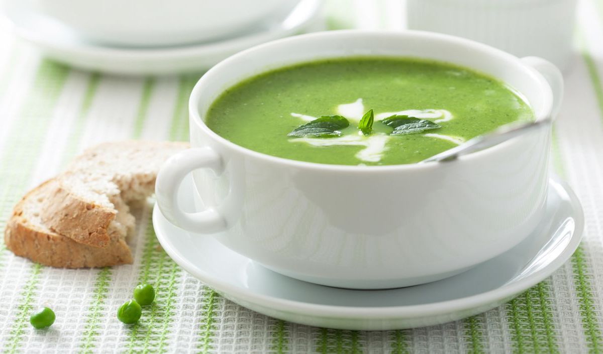 Erbsensuppe in einer Schüssel, daneben Brot