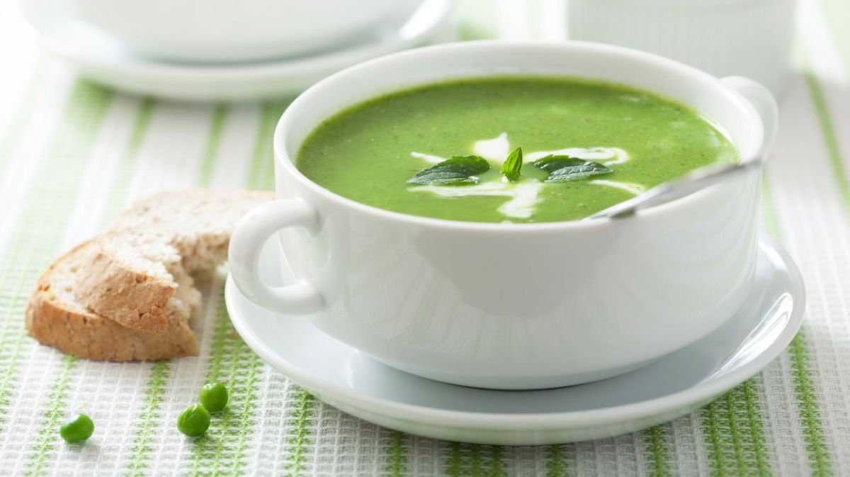 Erbsensuppe in einer Schüssel, daneben Brot