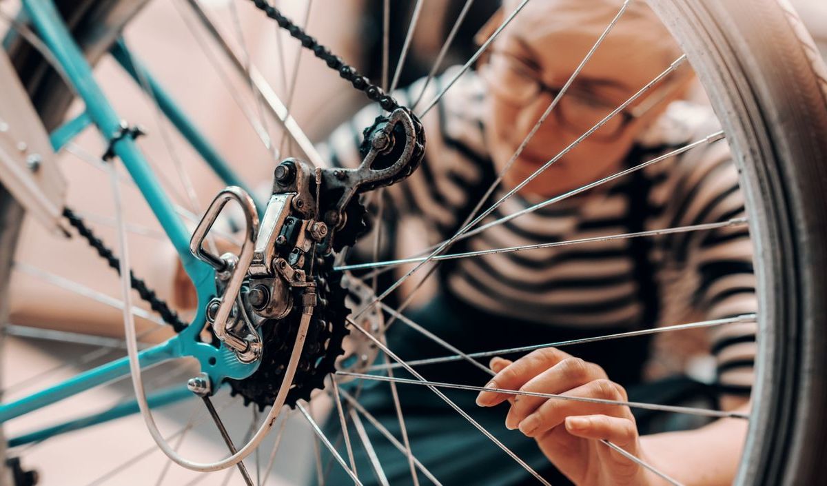 Eine Frau reinigt oder repariert ihr Fahrrad