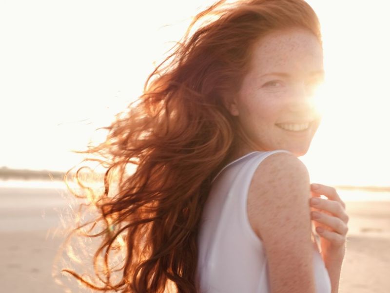 Frau am Strand im Sonnenuntergang am Lächeln 