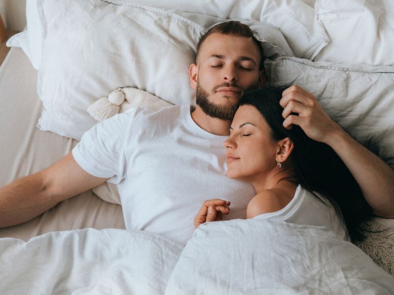 Pärchen kuschelt im Bett.